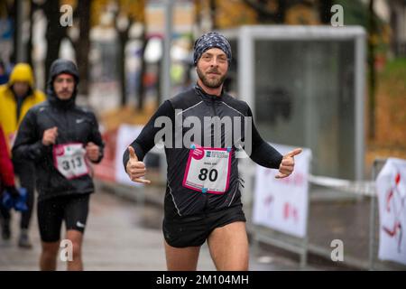 Les athlètes qui s'entraînent sous la pluie à l'occasion de la course de relais de marathon de Téléthon. Udine ville, Italie. 4 décembre 2022. Banque D'Images