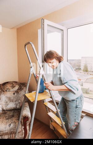 Happy Shy mature woman Cleaning House. Concept de la maison et des personnes à la retraite. Femme âgée nettoyage appartement. Femme sénior indépendante activée Banque D'Images