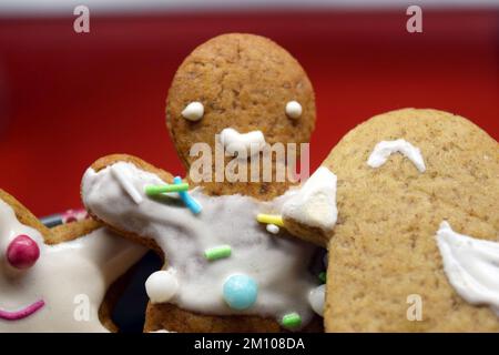 Figurines maison de pain d'épice sucré pour Noël décorées de glaçage blanc et de bonbons colorés : ours en peluche, homme de pain d'épice, arbre de Noël, étoiles. Banque D'Images