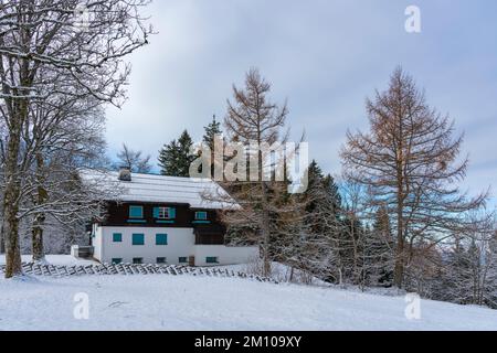 Holzhaus, Ferienhaus am Waldrand auf dem Hügel im ersten Schnee, verschneite Landschaft mit weißen Wiesen und Bäumen. Avent und Weihnachtszeit Ferien Banque D'Images