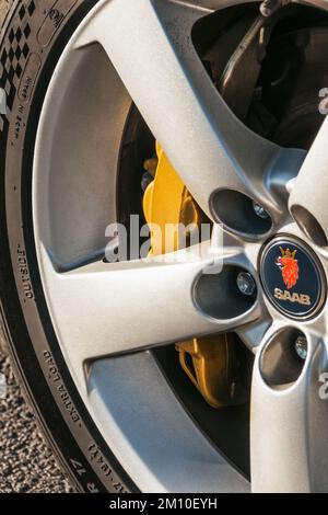 Ukraine, Chernihiv - 10 octobre 2022 : ancienne voiture suédoise Saab 9-3 Aero sur la route. Gros plan sur les roues d'une voiture Banque D'Images