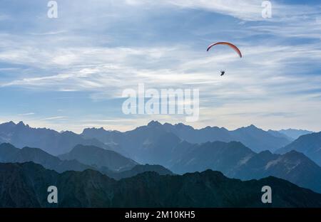 Parapente survolant Blue Mountains Silhouette, Allgaeu, Oberstdorf, Alpes, Allemagne. Destination du voyage. Concept liberté et vacances. Banque D'Images