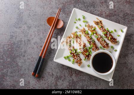 Les rouleaux de bœuf Enoki sont des hors-d'œuvre tendres et juteux faits à partir de savoureux champignons enoki enveloppés dans du bœuf finement coupé dans une assiette sur la table. Horizonta Banque D'Images