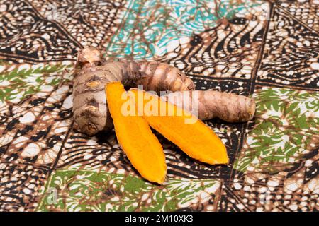 Curcuma frais sur une nappe de batik indonésienne. Banque D'Images