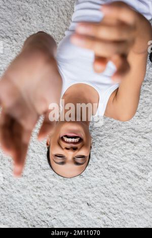 vue de dessus de positive afro-américaine femme en réservoir sur le tapis, image de stock Banque D'Images