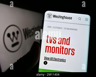 Personne tenant un téléphone cellulaire avec le site Web de la société américaine Westinghouse Electric Corporation à l'écran avec le logo. Concentrez-vous sur le centre de l'écran du téléphone. Banque D'Images