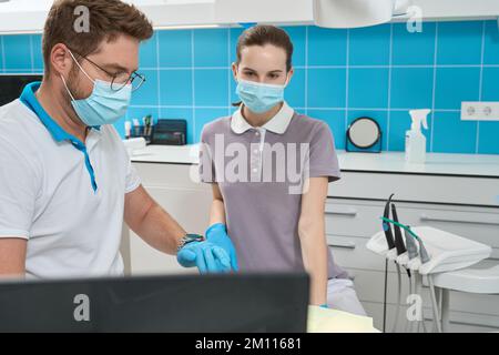 Dentiste et son assistant impliqués dans le traitement des patients Banque D'Images