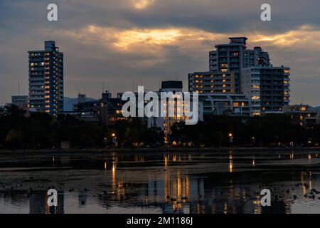 Immeubles d'appartements avec lumières au coucher du soleil dans les nuages Banque D'Images