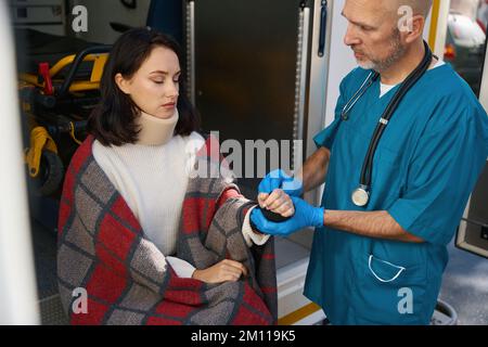 Un membre de l'équipage d'ambulance donne les premiers soins à une femme Banque D'Images