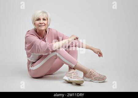 femme âgée active pose dans le studio sur fond blanc. concept de fitness. Banque D'Images