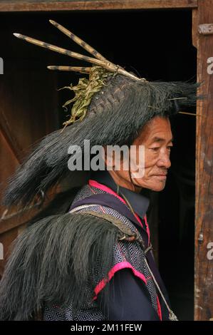 Ziro, Arunachal Pradesh, Inde - 03 05 2014 : Portrait de profil du vieux chaman tribal des Apatani avec chapeau rituel traditionnel avec cornes sur fond sombre Banque D'Images