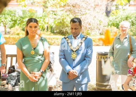 Le maire de Camden, Cllr Nasim Ali, observe un silence près du cerisier planté à la mémoire des victimes d'Hiroshima lors d'un événement à Londres. Banque D'Images