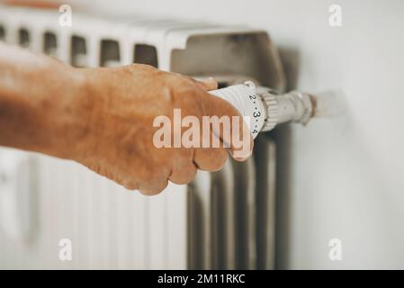 Gros plan de l'ancien thermostat de la maison de chauffage à fermeture manuelle pour économiser l'énergie du gaz. Concept des factures et des coûts de crise de la chaleur. Les gens ajustent l'alimentation du radiateur pour économiser de l'argent en hiver Banque D'Images