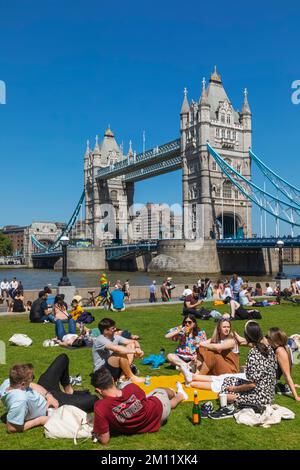 Tower Bridge avec des gens qui se détendent sur Grass à Foreground, Londres, Angleterre Banque D'Images