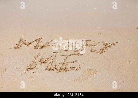 Me marier - comme un message écrit avec un doigt dans le sable sur une plage avec des vagues et l'océan bleu à l'île Maurice, Afrique, vue de dessus, personne Banque D'Images