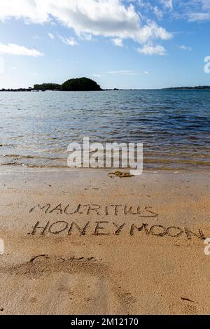 MAURICE LUNE DE MIEL message écrit avec un doigt dans le sable sur une plage avec des vagues et l'océan bleu à l'île Maurice, Afrique, vue de dessus, personne Banque D'Images