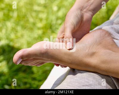 Marche pieds nus - gros plan avec le pied et la main, de la technique d'adhérence au massage de réflexologie du pied Banque D'Images