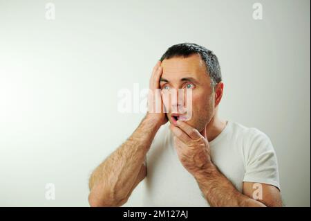 Portrait émotionnel gars se sentant naufrage coeur essoufflement au sujet du stress émotionnel sensations isolées sur fond gris blanc studio, peur personne, horreur panique concept d'attaque de panique homme Banque D'Images