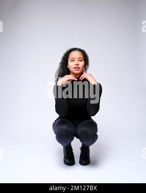 Jeune femme multiraciale qui fait face à un appareil photo | isolé sur fond blanc Banque D'Images