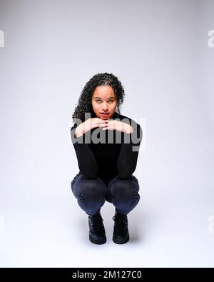 Jeune femme multiraciale qui fait face à un appareil photo | isolé sur fond blanc Banque D'Images