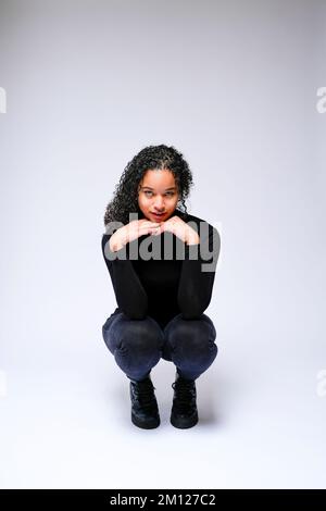 Jeune femme multiraciale qui fait face à un appareil photo | isolé sur fond blanc Banque D'Images