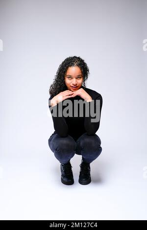 Jeune femme multiraciale qui fait face à un appareil photo | isolé sur fond blanc Banque D'Images