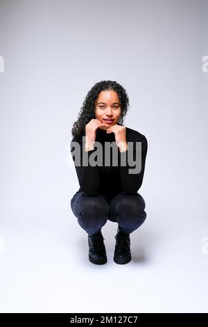 Jeune femme multiraciale qui fait face à un appareil photo | isolé sur fond blanc Banque D'Images