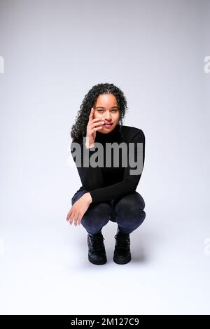 Jeune femme multiraciale qui fait face à un appareil photo | isolé sur fond blanc Banque D'Images