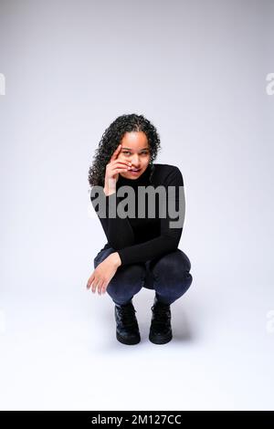 Jeune femme multiraciale qui fait face à un appareil photo | isolé sur fond blanc Banque D'Images