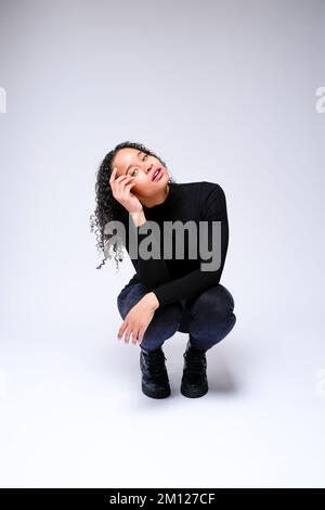 Jeune femme multiraciale qui fait face à un appareil photo | isolé sur fond blanc Banque D'Images