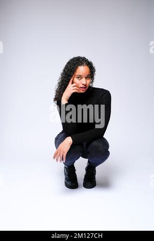 Jeune femme multiraciale qui fait face à un appareil photo | isolé sur fond blanc Banque D'Images