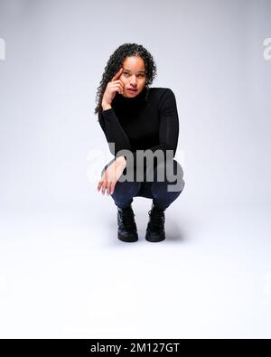 Jeune femme multiraciale qui fait face à un appareil photo | isolé sur fond blanc Banque D'Images