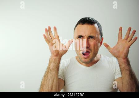 Portrait émotionnel gars se sentant naufrage coeur essoufflement au sujet du stress émotionnel sensations isolées sur fond gris blanc studio, peur personne, horreur panique concept d'attaque de panique homme Banque D'Images