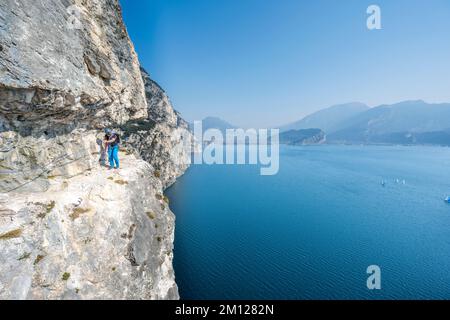 Pregasina, Riva del Garda, Trentin, Italie, Europe. Un grimpeur sur le chemin haut au-dessus du lac de Garde sur la route 'assimilano Torti', également appelé la route de Smuggler Banque D'Images