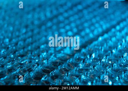Gros plan sur un film à bulles teinté bleu avec mise au point au plus près. Banque D'Images