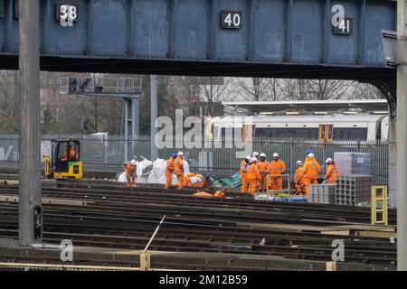 Londres, Royaume-Uni, 9 décembre 2022 : un groupe de personnel d'entretien ferroviaire en vêtements de sécurité orange hi-vis travaille sur une piste à la gare de Clapham Junction. Le syndicat RMT, qui représente les chauffeurs et le personnel d'entretien, a appelé à une série de grèves à partir de la mi-décembre et pendant la période de Noël. Anna Watson/Alay Live News Banque D'Images