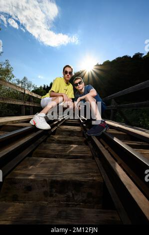 Ivano-Frankivsk, Ukraine 14 juillet 2022: Photo de deux adolescents sur un pont ferroviaire. une séance photo d'école. Banque D'Images
