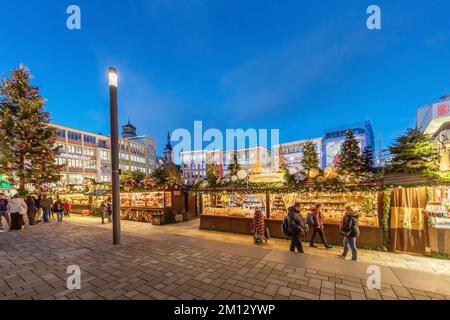 Marché de Noël Stuttgart, étals devant l'hôtel de ville avec vue sur la collégiale, les rangées de magasins et le grand magasin Breuninger Banque D'Images