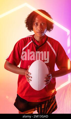 Six pans lumineux sur le portrait d'une femme de rugby biracial confiante tenant le ballon Banque D'Images