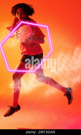 Joueur de rugby biracial féminin avec ballon sautant sur un motif hexagonal et abstrait illuminé Banque D'Images