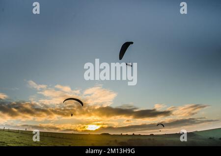 Firle, Lewes, East Sussex, Royaume-Uni. 9th décembre 2022. La brise très froide du nord amène les pilotes de parapente sur le site des glorieux Sussex Downs. Le vol a commencé après la levée du brouillard dans l'après-midi, laissant la brume sur la campagne environnante et le gel sur le sol. Des conditions plus froides sont prévues avec la possibilité de neige le dimanche. Crédit : David Burr/Alay Live News Banque D'Images