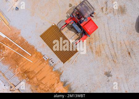 La livraison du chariot élévateur sur le site de construction renforce les barres d'acier en béton jusqu'aux fondations Banque D'Images