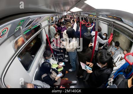 Les passagers utilisant des téléphones mobiles sur la station de métro MTR de Hong Kong, Hong Kong, Chine. Banque D'Images