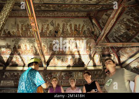 Visiteurs à Kertha Gosa, un pavillon emblématique que son plafond présentant l'ancien style traditionnel balinais kamasan, situé à Klungkung, Bali. Banque D'Images
