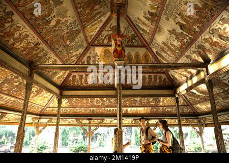 Visiteurs à Kertha Gosa, un pavillon emblématique que son plafond présentant l'ancien style traditionnel balinais kamasan, situé à Klungkung, Bali. Banque D'Images