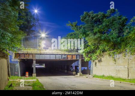 Vue nocturne de 20th Street à Detroit sous les voies ferrées surélevées de la gare centrale du Michigan, Detroit, Michigan, États-Unis. Banque D'Images