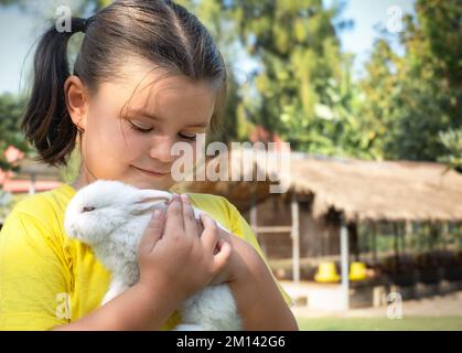 Portrait d'une fille avec un lapin blanc sur une ferme en été Banque D'Images