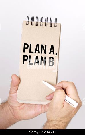 Concept commercial et financier. Un homme tient un stylo et un nœud dans ses mains avec l'inscription - Plan A, Plan B Banque D'Images