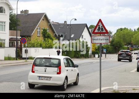 Hellerup, Danemark - 14 juin 2022: Signalisation routière pour les enfants près d'une école dans une rue de banlieue avec maisons individuelles. Banque D'Images