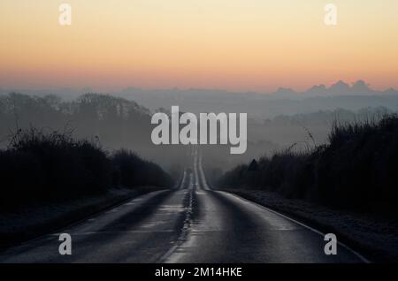 La brume entoure les champs tandis que l'aube se brise sur la A272 près de Winchester dans le Hampshire. De grandes régions du pays ont été prévenus de s'attendre à des conditions difficiles pendant le week-end, avec des prévisions de neige pour l'Écosse et le sud-est de l'Angleterre. Date de la photo: Samedi 10 décembre 2022. Banque D'Images